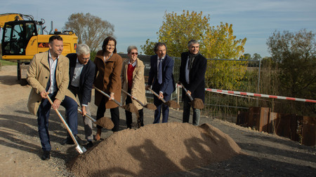 Vertreter aus Sachsen-Anhalt und Thüringen stehen mit Spaten ausgerüstet vor einem Sandhaufen und starten symbolisch die Arbeiten zur Sanierung des Helme-Deiches.