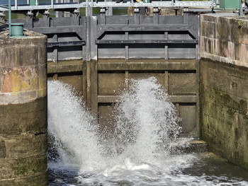 Blick auf die Tore der Oeblitzschleuse, aus denen Wasser strömt